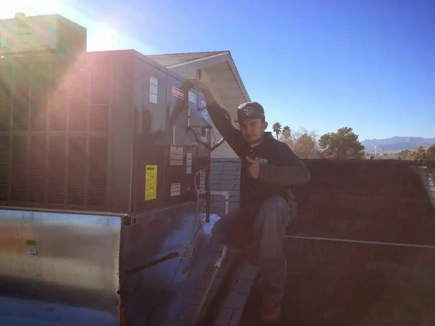 HVAC technician performing HVAC Inspection on a rooftop unit in Huntersville